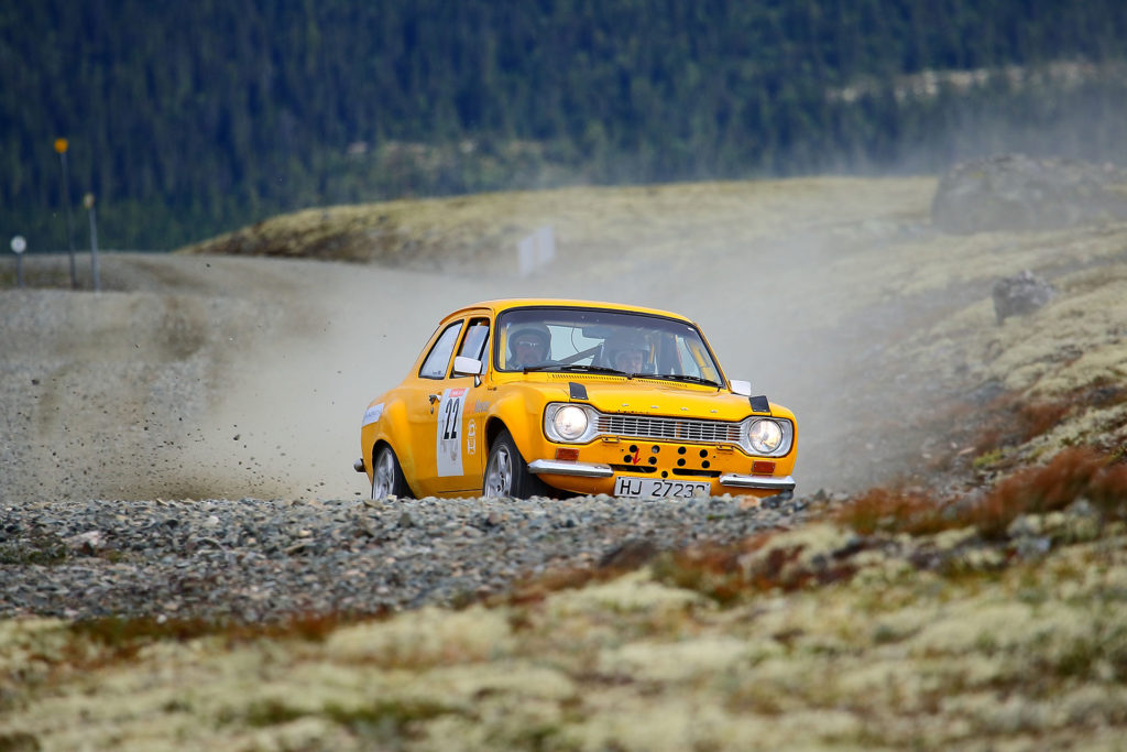 Gul rallybil oppover Tronfjell på Rally Tron, med støvsky bak seg
